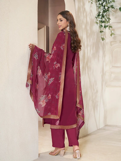 Woman in a maroon kurta set traditional outfit with floral patterns in a decorated room.Woman in a maroon kurta set traditional outfit with floral patterns in a decorated room.