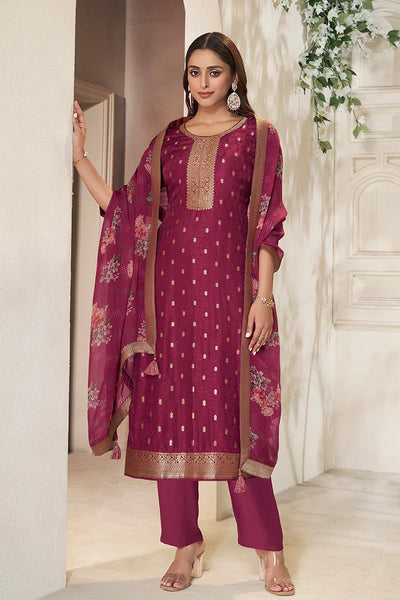 Woman wearing a maroon traditional outfit with a matching dupatta in an elegant indoor setting.
