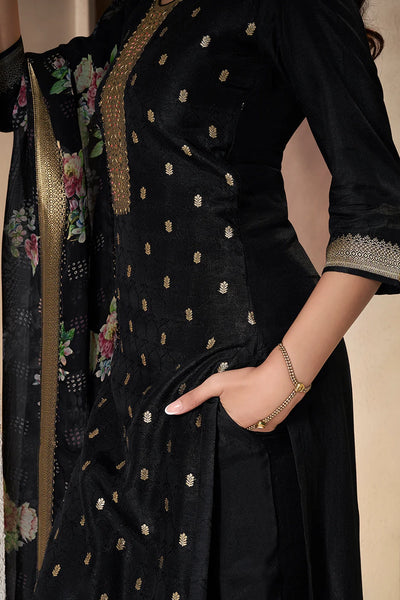 Black traditional kurta set outfit with gold embroidery, held by a hand against a neutral backgroundBlack traditional kurta set outfit with gold embroidery, held by a hand against a neutral background
