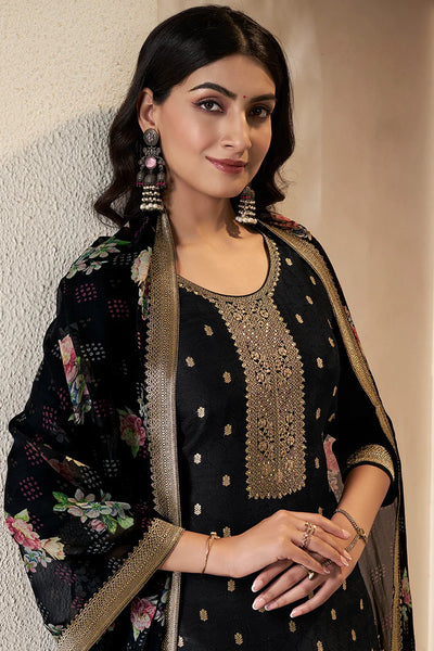 Woman wearing a black embroidered kurta set outfit with a black floral print dupatta against a neutral backgroundWoman wearing a black embroidered kurta set outfit with a black floral print dupatta against a neutral background