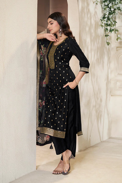 Woman wearing a black kurta set traditional outfit with gold embroidery in an indoor setting.Woman wearing a black kurta set traditional outfit with gold embroidery in an indoor setting.