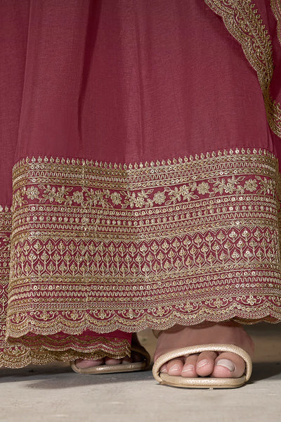 Close-up of a pink anarkali traditional outfit with gold embroidery and sandals on a neutral backgroundClose-up of a pink anarkali traditional outfit with gold embroidery and sandals on a neutral background