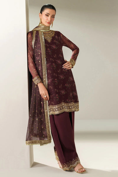 Woman wearing a traditional salwar suit outfit with a long embroidered kameez and matching salwar on a plain backgroundWoman wearing a traditional salwar suit outfit with a long embroidered kameez and matching salwar on a plain background