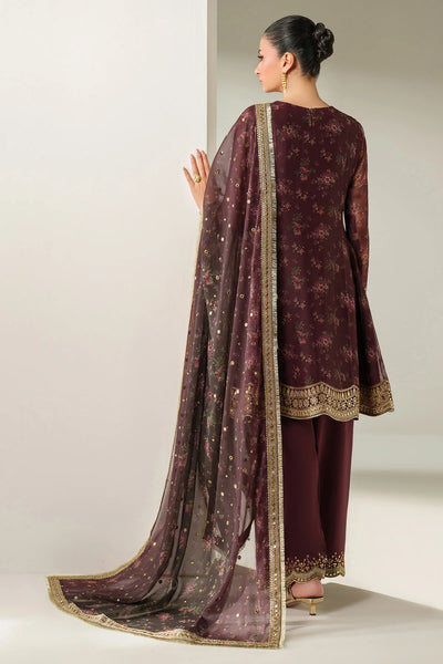 Woman wearing a traditional salwar suit outfit with a long embroidered kameez and matching salwar on a plain backgroundWoman wearing a traditional salwar suit outfit with a long embroidered kameez and matching salwar on a plain background