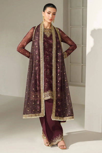Woman wearing a traditional salwar suit outfit with a long embroidered kameez and matching salwar on a plain backgroundWoman wearing a traditional salwar suit outfit with a long embroidered kameez and matching salwar on a plain background