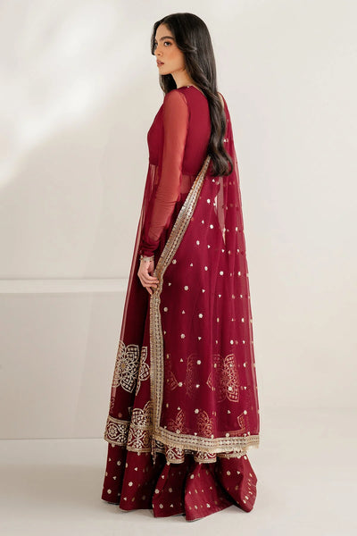 Woman wearing a long maroon anarkali dress with gold embroidery on a white backgroundWoman wearing a long maroon anarkali dress with gold embroidery on a white background