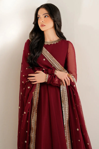 Woman wearing a long maroon anarkali dress with gold embroidery on a white backgroundWoman wearing a long maroon anarkali dress with gold embroidery on a white background