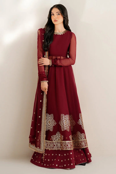 Woman wearing a long maroon anarkali dress with gold embroidery on a white backgroundWoman wearing a long maroon anarkali dress with gold embroidery on a white background