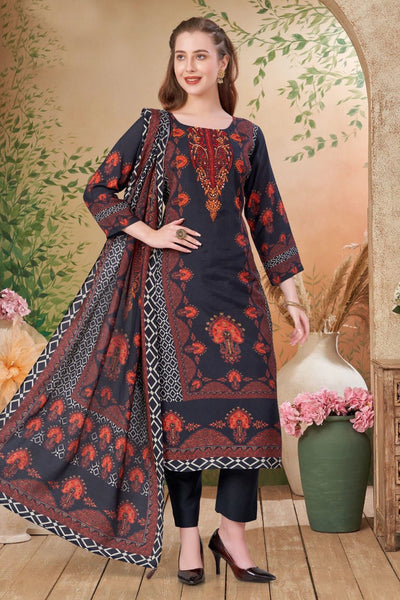 Woman wearing a dark blue embroidered Kurta Suit Set with a patterned dupatta in a decorative setting.