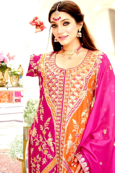 Woman wearing a traditional pink and orange embroidered outfit with jewelry.Woman wearing a traditional pink and orange embroidered outfit with jewelry.