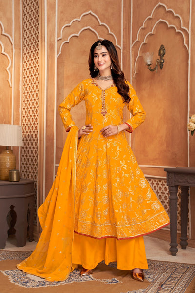 Woman in a bright yellow traditional outfit standing in an ornate room.
