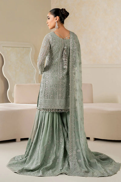 Woman wearing a light green traditional wedding sharara outfit with a matching dupatta in a room.Woman wearing a light green traditional wedding sharara outfit with a matching dupatta in a room.