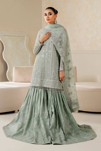 Woman wearing a light green traditional wedding sharara outfit with a matching dupatta in a room.Woman wearing a light green traditional wedding sharara outfit with a matching dupatta in a room.
