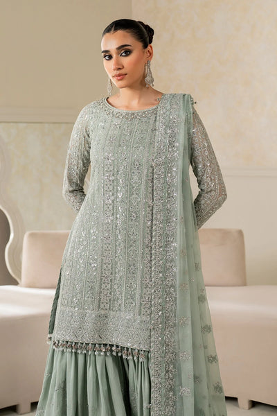 Woman wearing a light green traditional wedding sharara outfit with a matching dupatta in a room.Woman wearing a light green traditional wedding sharara outfit with a matching dupatta in a room.