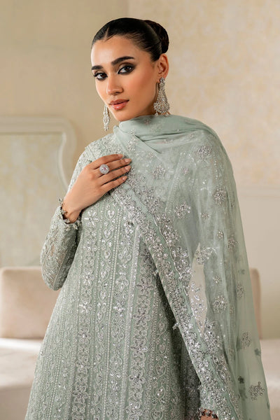 Woman wearing a light green traditional wedding sharara outfit with a matching dupatta in a room.Woman wearing a light green traditional wedding sharara outfit with a matching dupatta in a room.