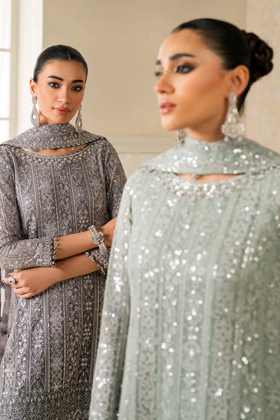 Woman wearing a light green traditional wedding sharara outfit with a matching dupatta in a room.Woman wearing a light green traditional wedding sharara outfit with a matching dupatta in a room.