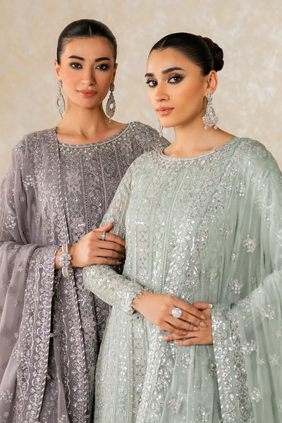 Woman wearing a light green traditional wedding sharara outfit with a matching dupatta in a room.Woman wearing a light green traditional wedding sharara outfit with a matching dupatta in a room.