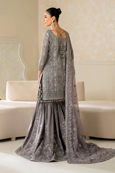 Woman in a gray traditional outfit standing in a room with beige walls and furniture.Woman in a gray traditional outfit standing in a room with beige walls and furniture.
