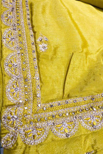 Close-up of a yellow fabric with intricate silver embroideryClose-up of a yellow fabric with intricate silver embroidery