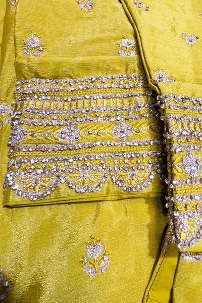 Close-up of a yellow fabric with intricate silver embroideryClose-up of a yellow fabric with intricate silver embroidery
