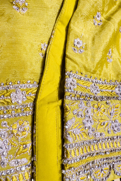 Close-up of a yellow fabric with intricate silver embroideryClose-up of a yellow fabric with intricate silver embroidery