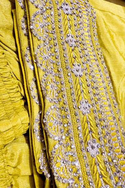 Close-up of a yellow fabric with intricate silver embroideryClose-up of a yellow fabric with intricate silver embroidery