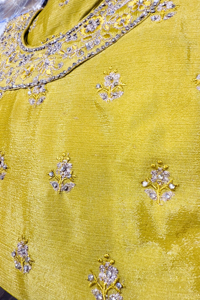Yellow fabric with intricate floral embroidery and embellishmentsYellow fabric with intricate floral embroidery and embellishments