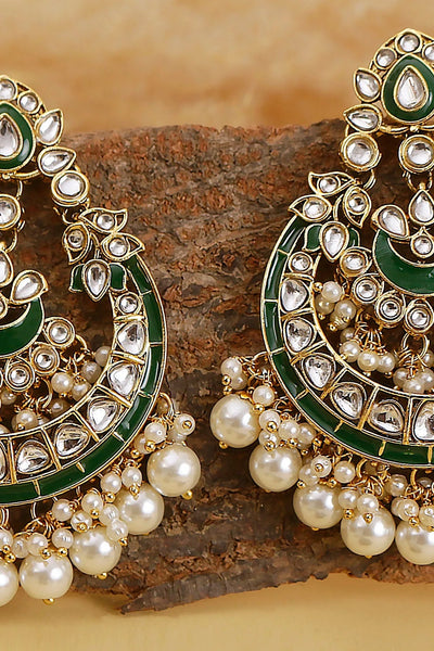 Ornate earrings with green and gold accents on a wooden surfaceOrnate earrings with green and gold accents on a wooden surface