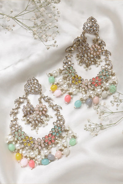 Decorative earrings with colorful beads on a white fabric background