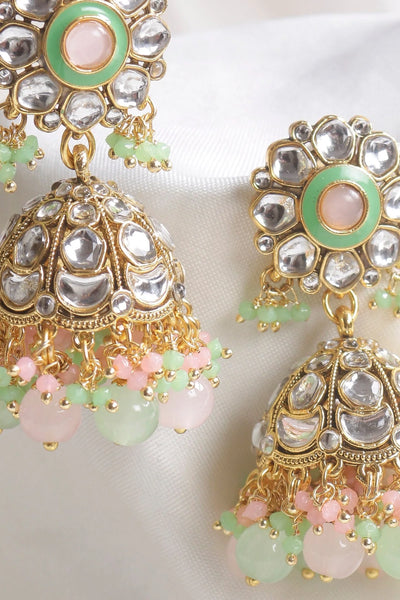 Close-up of ornate earrings with gold, silver, and pastel gemstone details.Close-up of ornate earrings with gold, silver, and pastel gemstone details.
