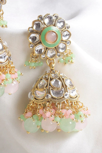 Ornate earrings with gold, silver, and pastel gemstone details on a white backgroundOrnate earrings with gold, silver, and pastel gemstone details on a white background