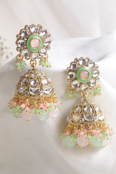 Ornate earrings with gold, green, and pink details on a white background