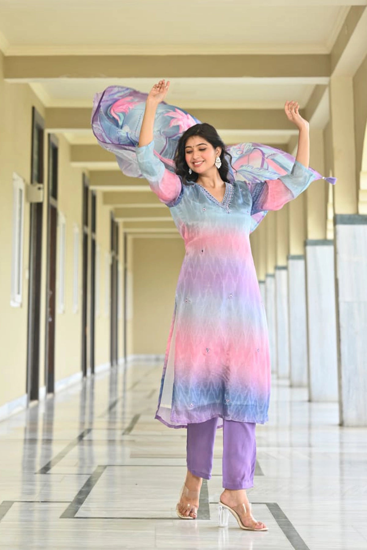 Woman in a colorful outfit standing in a hallway