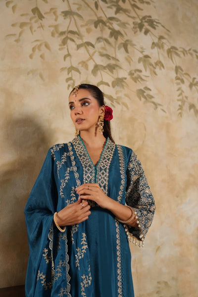 Woman in a blue embroidered outfit with a floral backgroundWoman in a blue embroidered outfit with a floral background