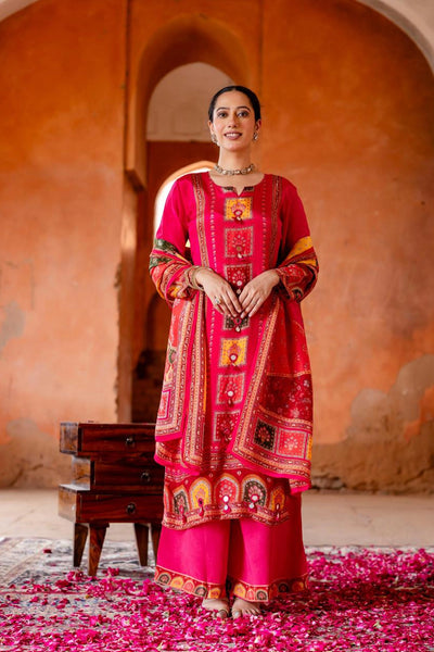Woman in a traditional red and pink outfit standing in front of an archway with pink petals on the ground.Woman in a traditional red and pink outfit standing in front of an archway with pink petals on the ground.