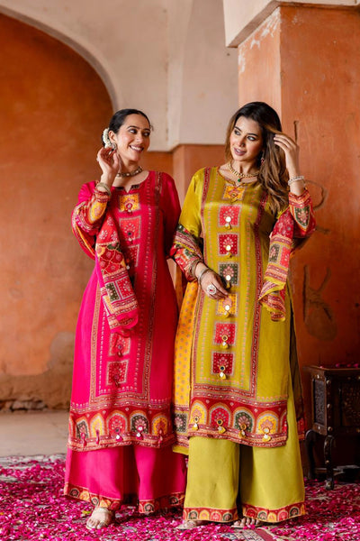Two women in colorful traditional outfits standing in a decorative indoor setting.Two women in colorful traditional outfits standing in a decorative indoor setting.