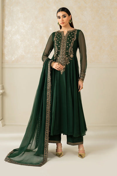 Woman wearing a green embroidered traditional anarkiali outfit with a chiffon dupatta against a neutral background