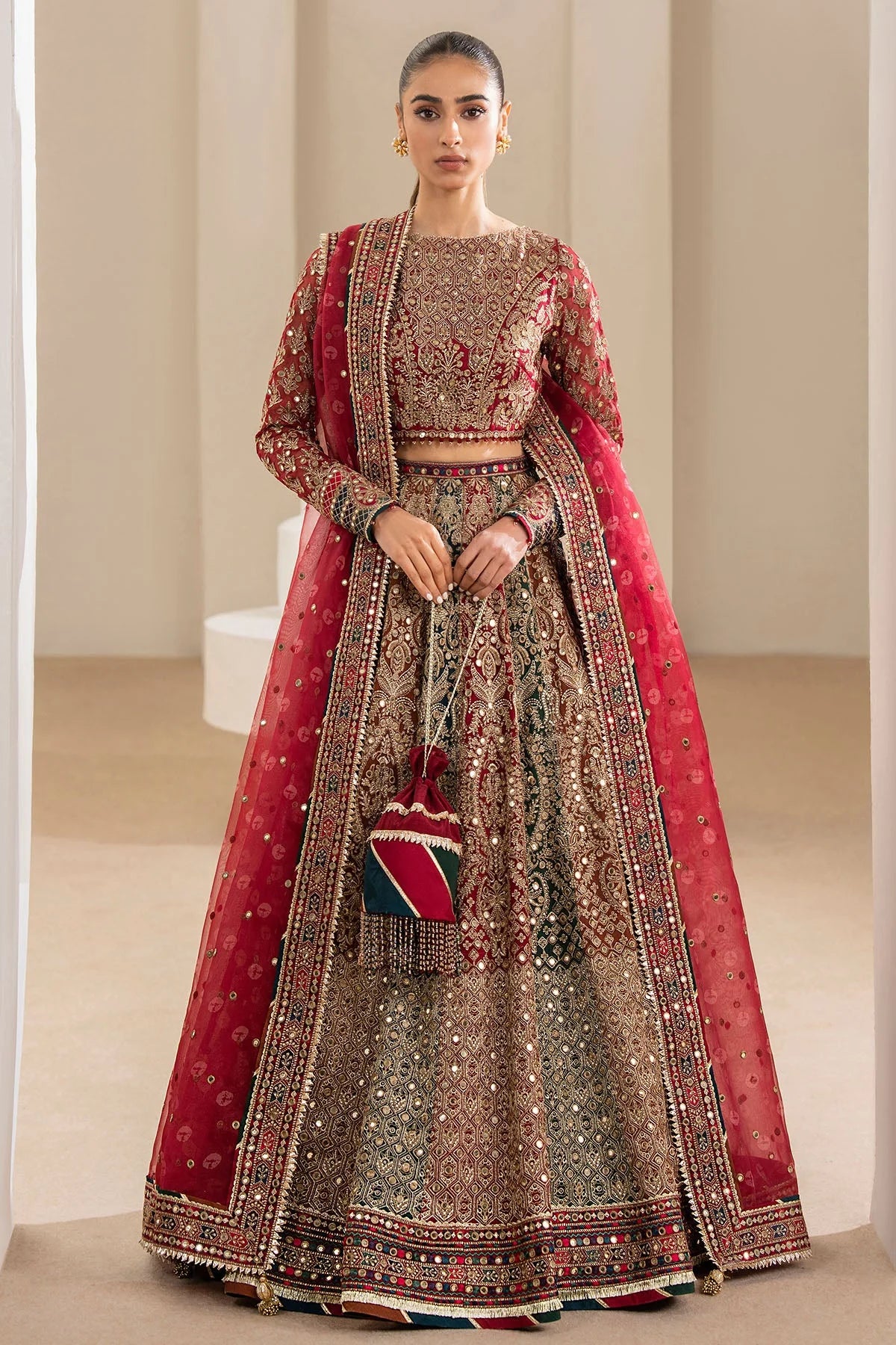 Woman wearing a traditional red embroidered Chiffon Bridal Lehenga outfit with a red dupatta in a neutral setting