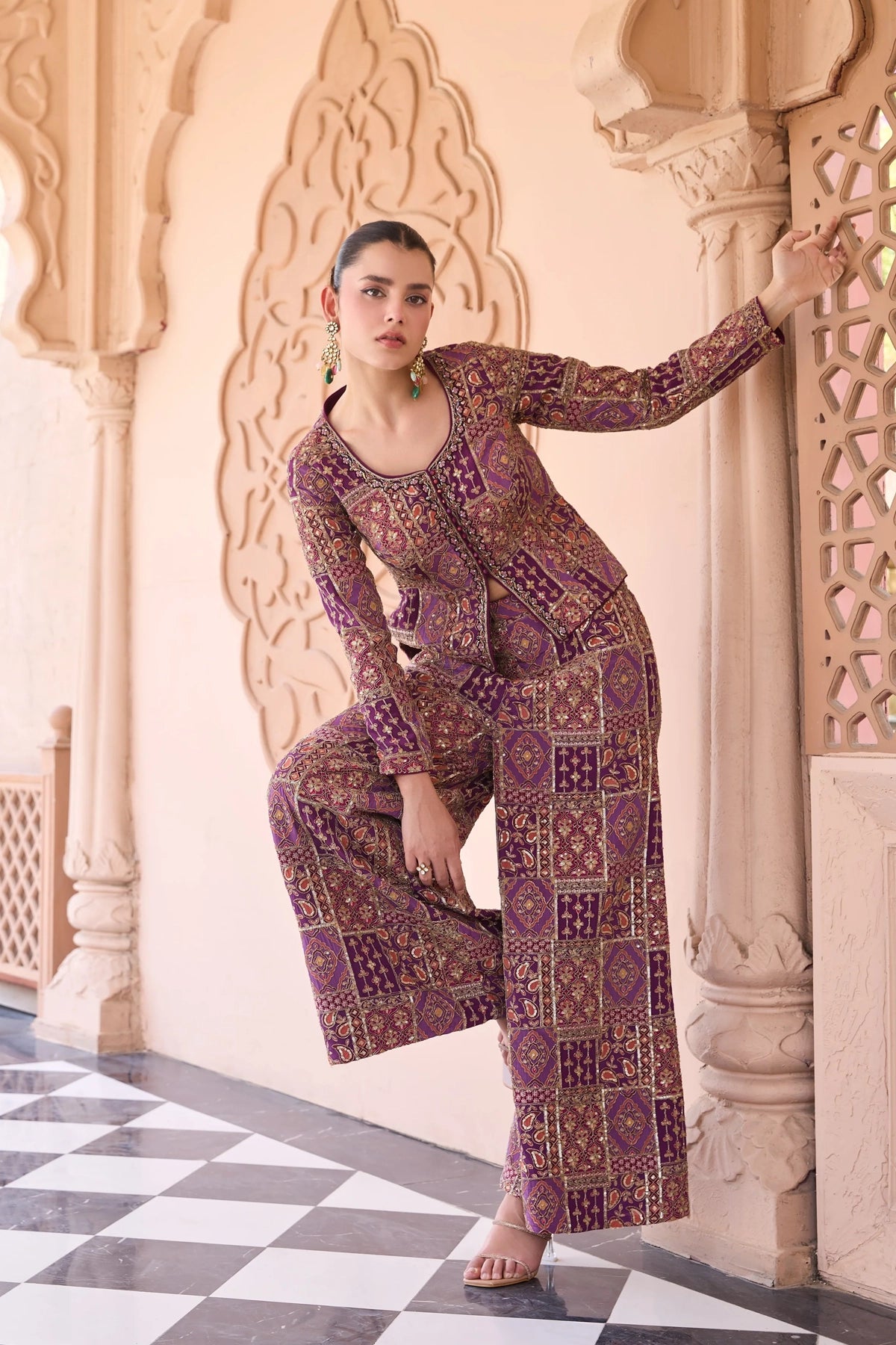 Woman in a embroidered palazzo outfit standing in an ornate architectural setting