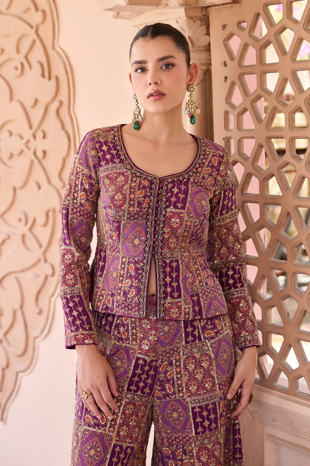 Woman wearing a embroidered palazzo outfit in front of decorative wall