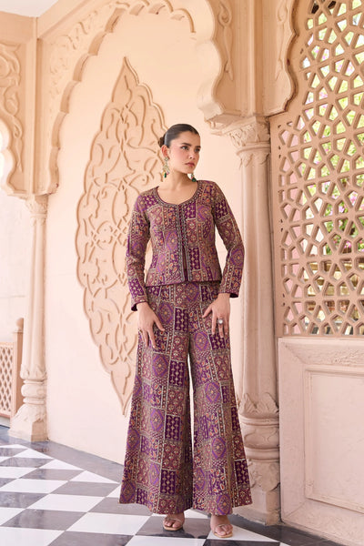 Woman in a patterned outfit standing in front of ornate architectural elements.
