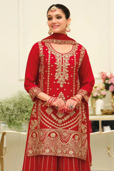 Woman wearing a red chinon silk embroidered traditional sharara outfit in an elegant indoor setting.Woman wearing a red chinon silk embroidered traditional sharara outfit in an elegant indoor setting.