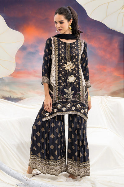 Woman wearing a black embroidered traditional outfit with a colorful background