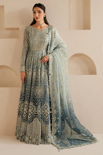 Woman wearing a traditional embroidered anarkali outfit with a sheer dupatta in a minimalistic setting