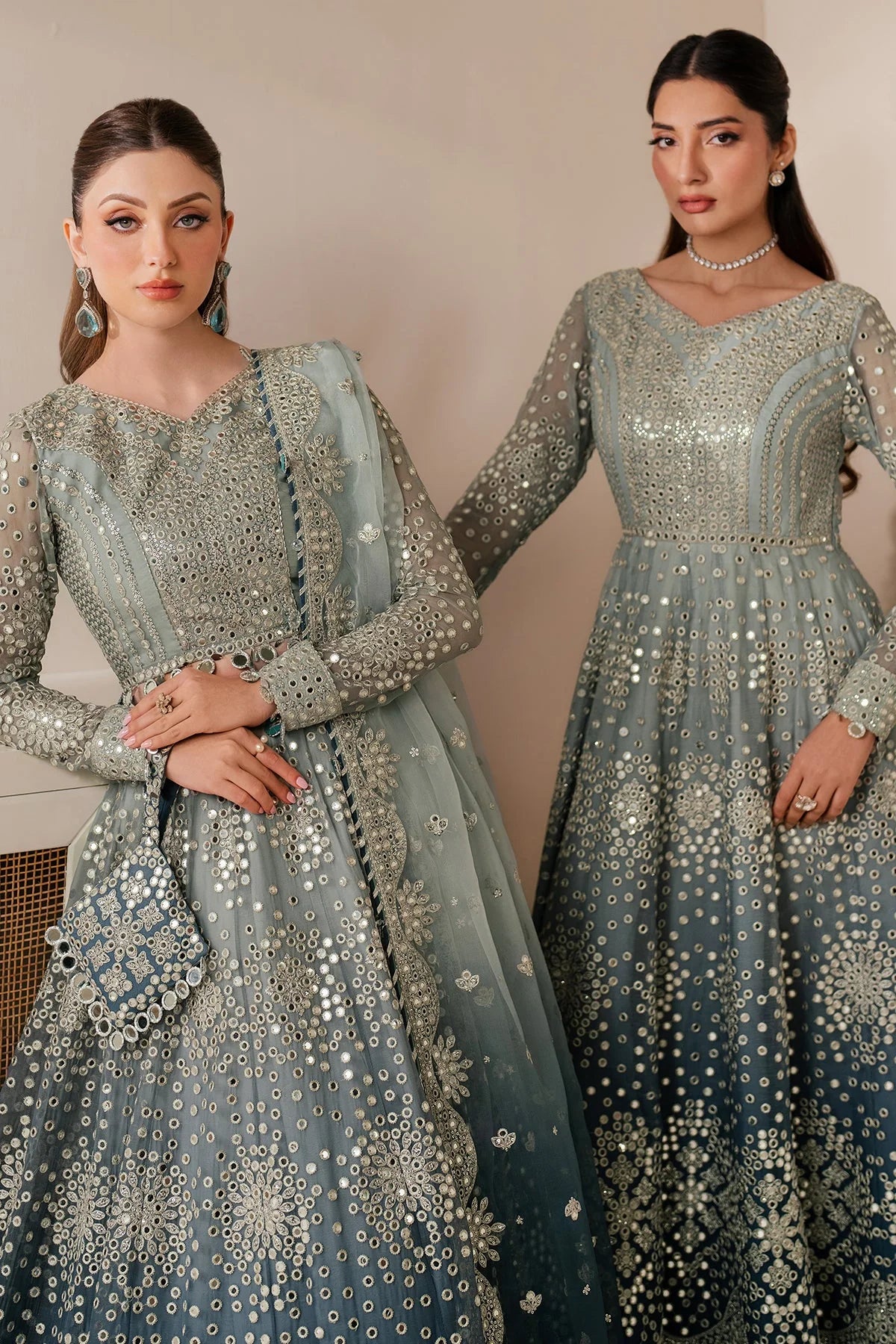 Woman wearing a light blue embroidered traditional anarkali outfit with a white background