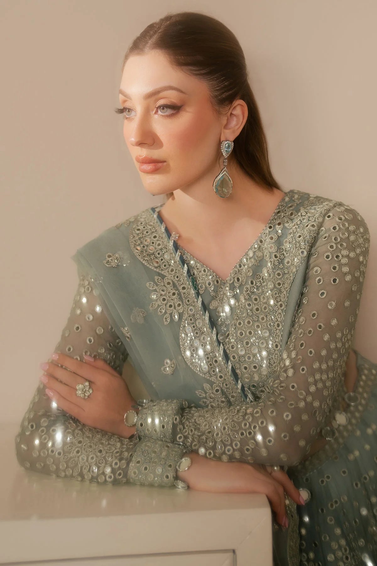 Woman wearing a traditional Lehenga choli outfit with intricate designs in a neutral setting