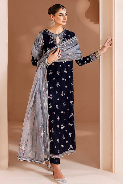 Woman in a navy blue velvet kurta set traditional outfit with silver embroidery in a neutral setting