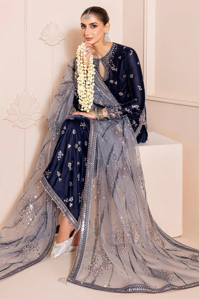 Woman in a navy blue velvet kurta set traditional outfit with silver embroidery in a neutral settingWoman in a navy blue velvet kurta set traditional outfit with silver embroidery in a neutral setting
