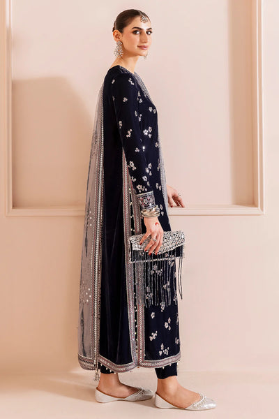Woman in a navy blue velvet kurta set traditional outfit with silver embroidery in a neutral settingWoman in a navy blue velvet kurta set traditional outfit with silver embroidery in a neutral setting
