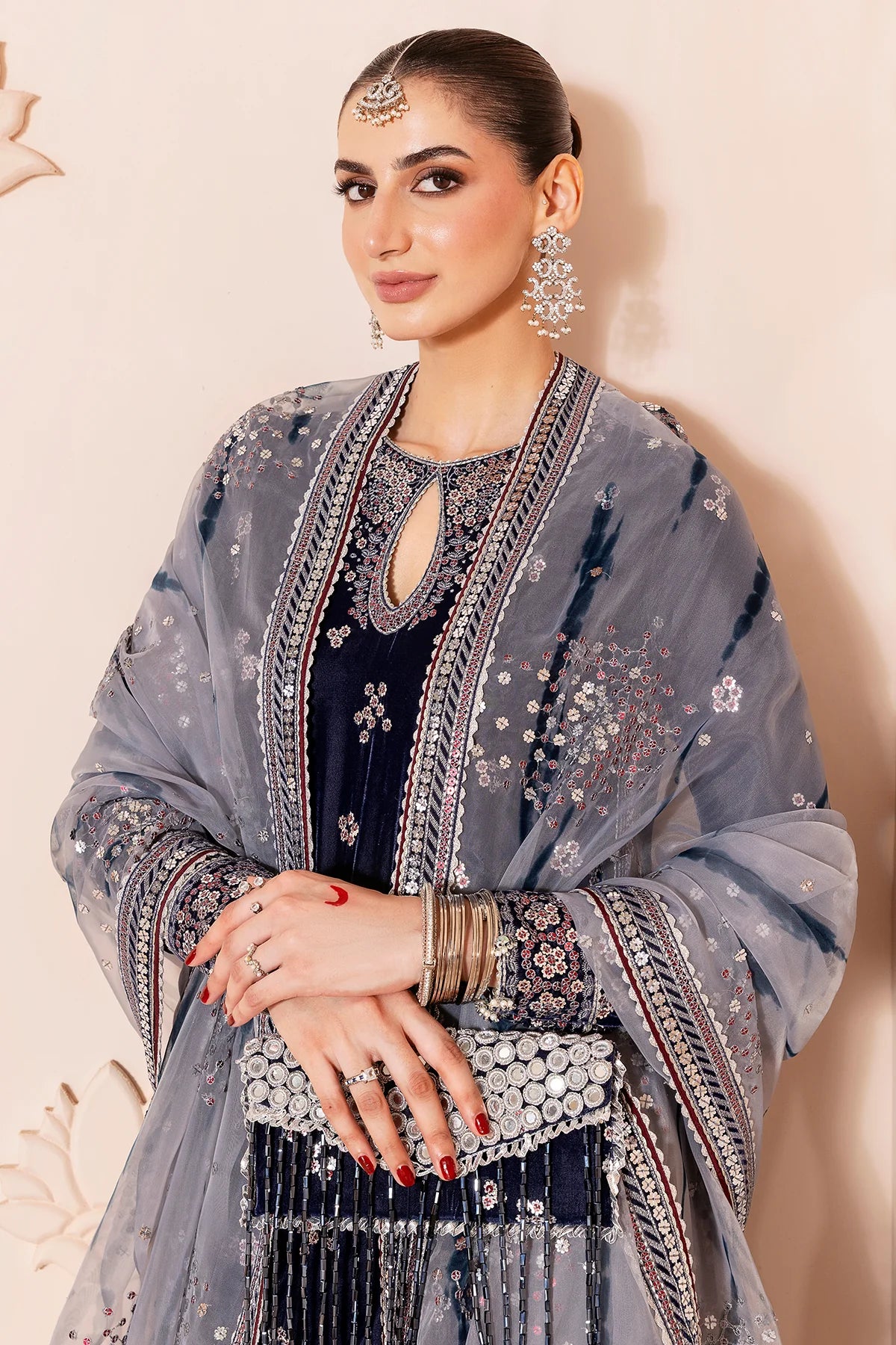 Woman in a navy blue velvet kurta set traditional outfit with silver embroidery in a neutral setting